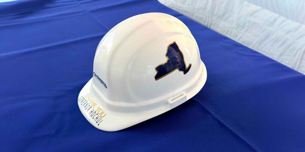White hard hat with a New York–shaped vinyl decal and thank-you lettering on the brim
